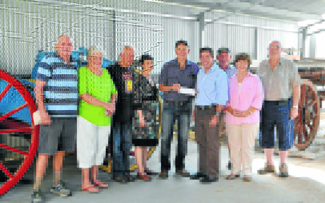 Surrounded by members, Bathurst MP and Minister for Local Government Paul Toole, right, presents a grant for $10,000 to Millthorpe's Golden Memories Museum President Peter Whiley.