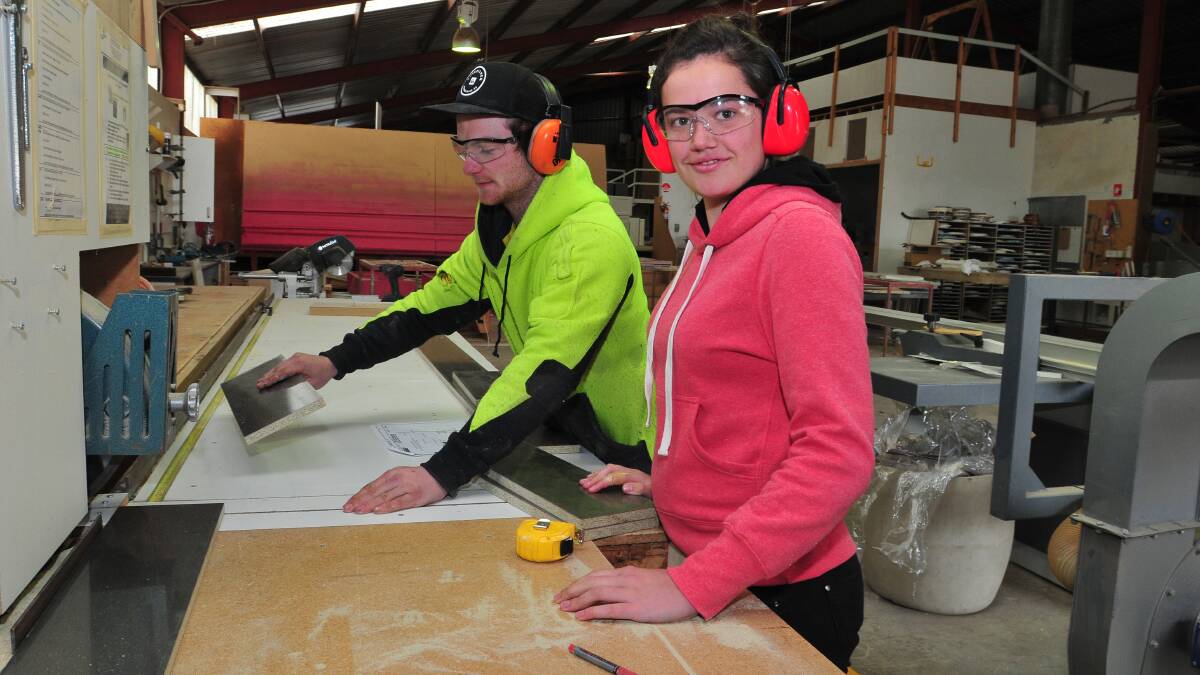 LEARNING EXPERIENCE: JD Kitchens apprentice Caine Ind shows Blayney High School student Eliza Ewin how to make cabinets during her work experience last week. Photo: JUDE KEOGH 0905tradie