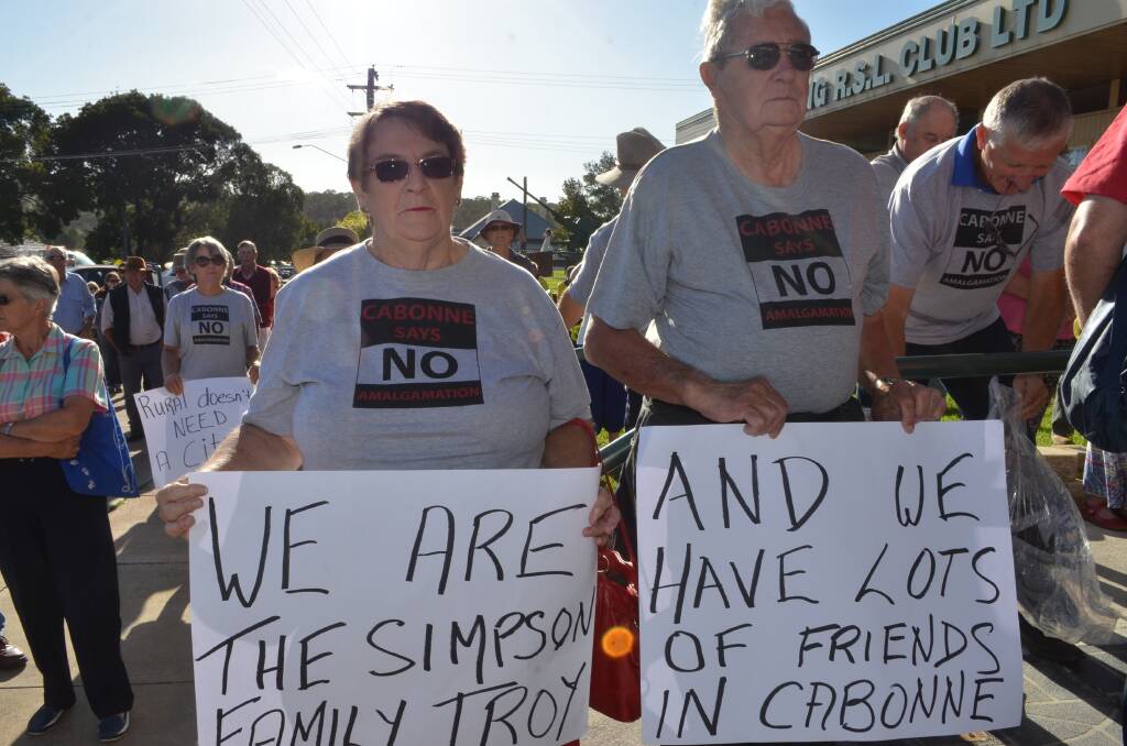 CLEAR REMINDER: Heather and Colin Woodhouse make a point with their placards after deputy premier Troy Grant reportedly compared Cabonne residents to the dysfunctional cartoon family, The Simpsons. Photo: DANIELLE CETINSKI  0205dcmolong15