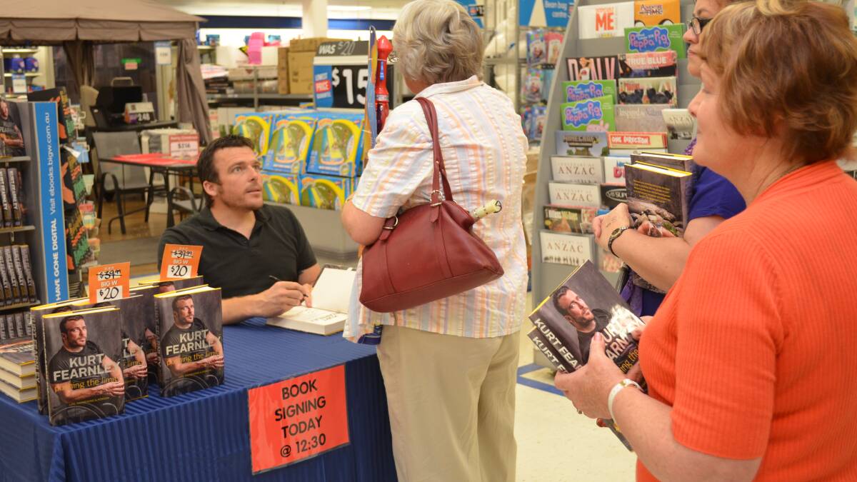 INSPIRATIONAL WRITER: Kurt Fearnley (left) signs copies of his biography. 
Photo: DANIELLE CETINSKI 1211dcbooksign2