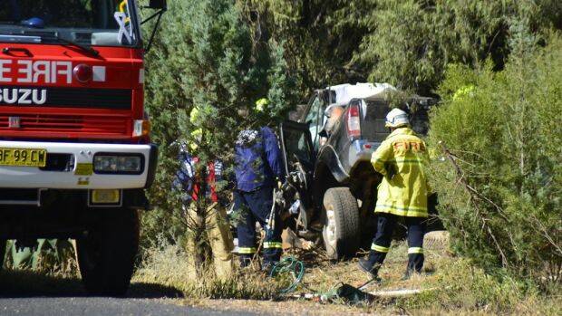 HORROR SCENE: Emergency services examine the wreckage on the Mitchell Highway. Photo: BRIAN HARVEY