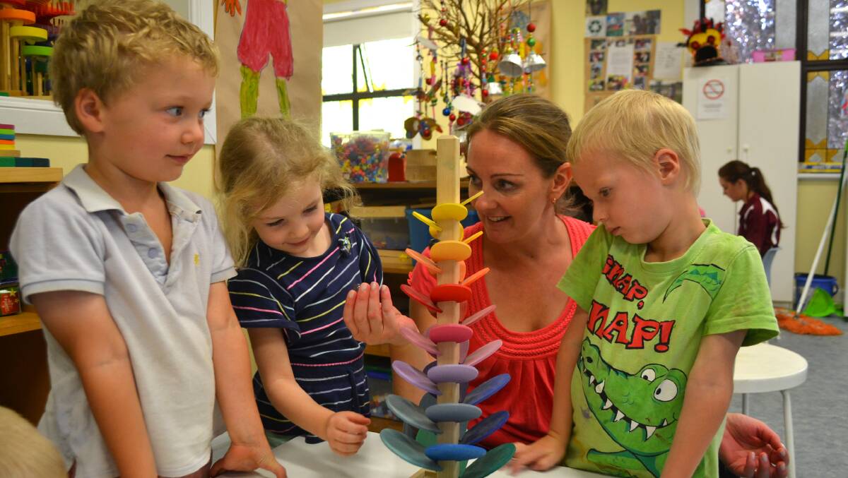 Teacher Johannah Francis leads children William Wilson, Amelia Hanman and Kayden Burns in a game with a different take on marbles. 
