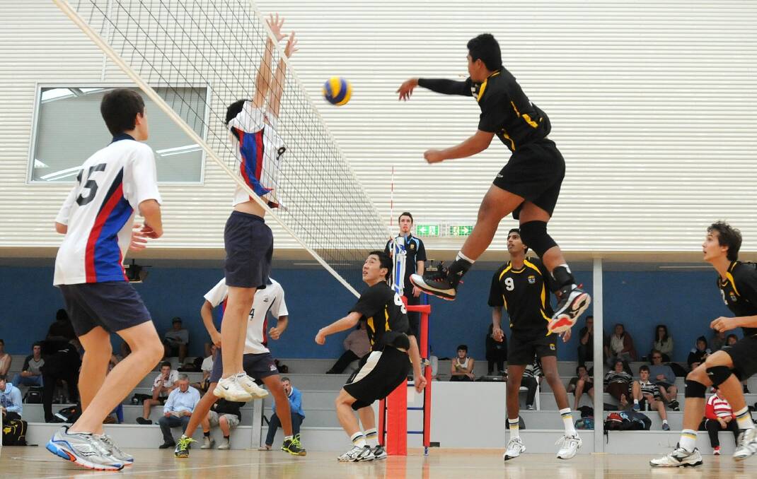 AIR TIME: Mark Torzar slams the ball for Sydney West (right) in the NSW Combined High Schools boys’ volleyball championship final against Sydney East (left) yesterday.  Photo: STEVE GOSCH 0327sgvolley