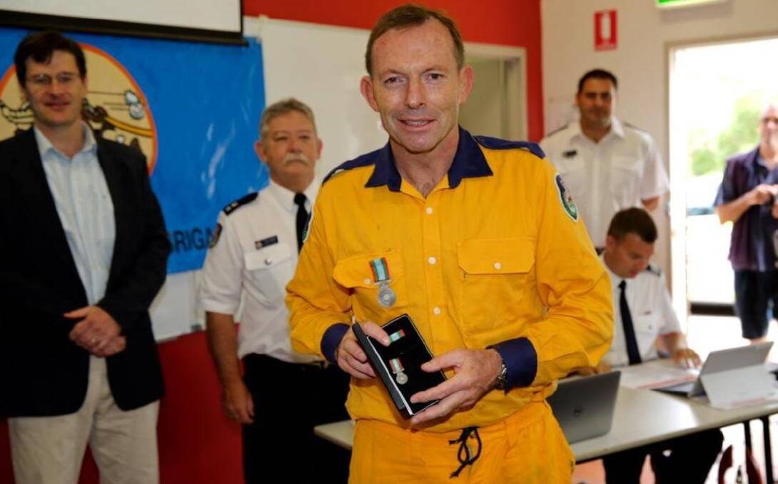 Then Prime Minister Tony Abbott receives a 10-year service medal from the Davidson Rural Fire Brigade in 2015. Photo: TWITTER/@TonyAbbottMHR