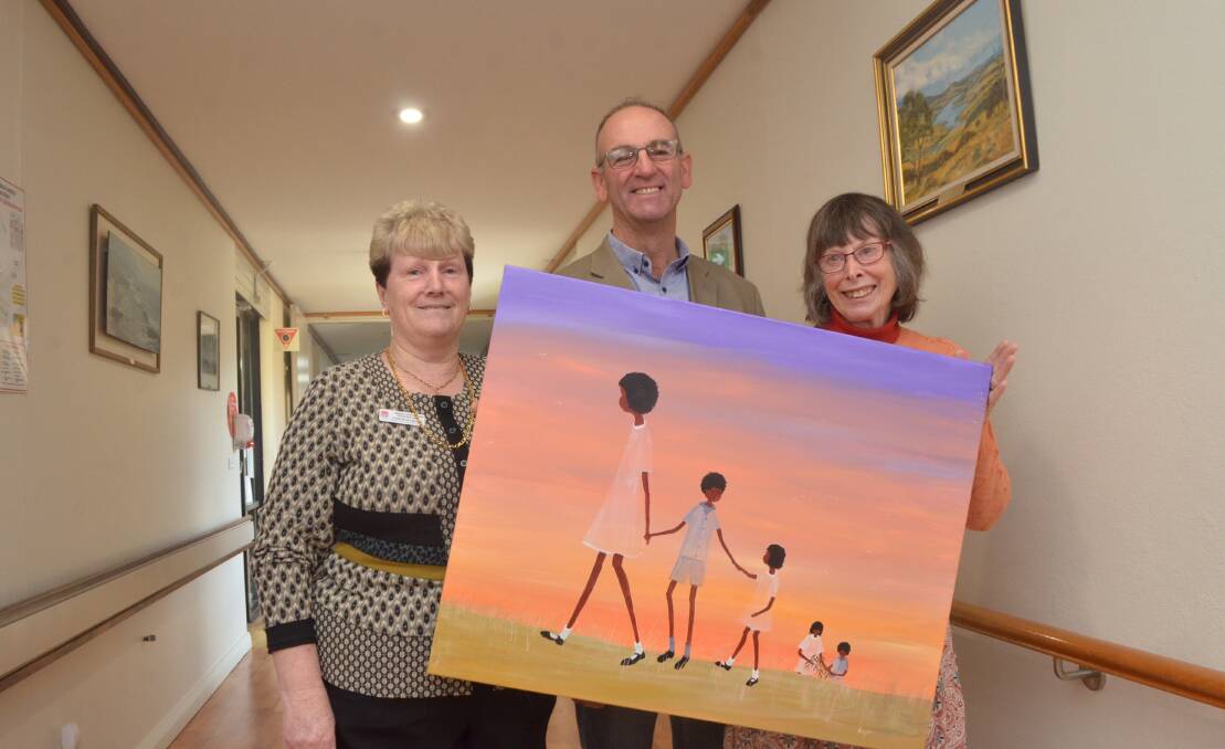 ART: Blayney District Hospital's Kathy Hillier, mayor Scott Ferguson and artist Nyree Reynolds with one of five paintings for Reconcilation Week.