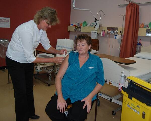 IPC nurse specialist, Sue Lovell-Smart, gives Blayney Hospital hotel services staff member Tracey Bowman her flu vaccination.