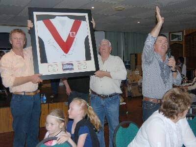 CARING COMMUNITY: Cliff Wills, Jim Maher and Steve Mooney take a flurry of bids on this rare St George jersey at Jessie's fundraiser.
