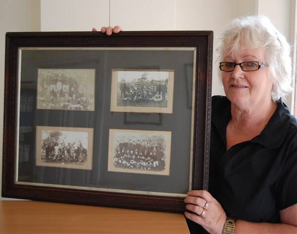 Sunny Ridge Golf club manager, Edna Maynard, with photos of former Carcoar Football Club members that date back as far as 1890. Former players and supporters of the club will reunite on January 23. Photo: Clare Colley