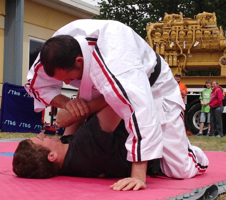 Aussie Martial Arts demonstration at the Creative Corner of the Blayney Festival. Thomas Field (in black), who's ranked third in the world for his class, tackles his teacher, Sensei Terry Hunt. Photo: Margaret Paton