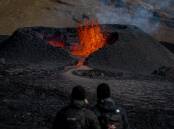 Tourists look at at lava flowing from a heart-shaped crater at the Fagradalsfjall volcano in Iceland on Monday, August 15, 2022. Photo: Aaron Chown/PA Images via Getty Images.