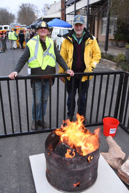 In charge: Fire warden Bruce Yarnold and John Harrison enjoy the warmth from the firepits. 