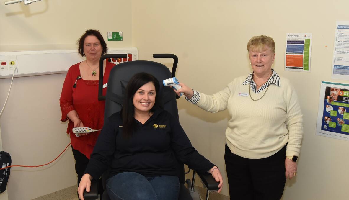 Easy read: Deb Higgs watches on as CVO's Melissa O'Brien tests out the new treatment chair and Kathy Hillier takes her temperature. Photo: Mark Logan.
