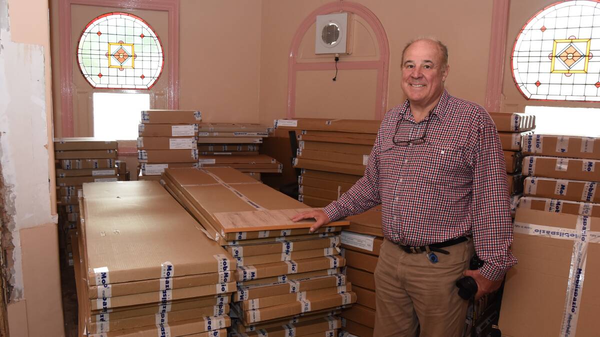 PACKING IT IN: Mr Gillings with just some of the custom made flat-pack furniture he has ordered for the room renovations. Photo: Mark Logan.
