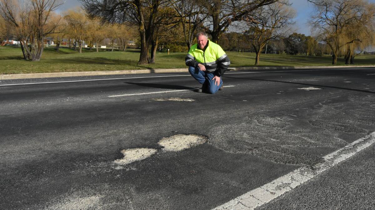 Crater capers: Councillor Bruce Reynolds investigating some of the potholes that have appeared on Orange Road. Photo: Mark Logan.