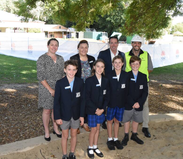 GROWING: Ellie McNamara, Penny Granger, Paul Toole and Andrew Middleton with Jake Booth, Abbie Bird, Lucy Campbell and Ned Price in front of the construction site.