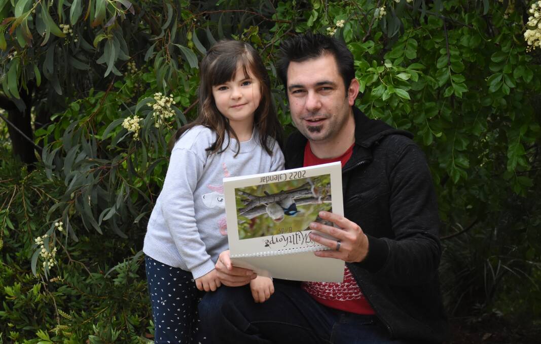 OF A FEATHER: Kane Strangwidge and his daughter Addison with a copy of the Birds of Millthorpe calendar. Photo: Mark Logan.