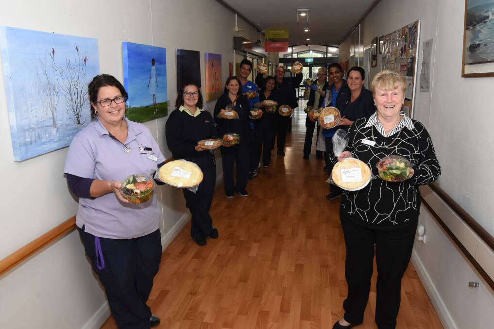 Well deserved: Jillian Pettit and Kathy Hillier with staff from Blayney Multipurpose Service with their Akehurst Bakery pies and side salads. Photo: Mark Logan. 