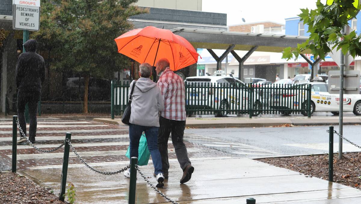 Pedestrians dodge the rain in Orange on Anson Street. Picture by Carla Freedman