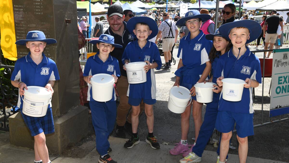 Milthorpe Public School students Summer Whitelaw, Charlotte Vella, teacher Matt Dunn, Max Lockwood, Georgie Johnson, Billy Lockwood, Jaylyn Johnson collected gold coin donations at the gate for entry to the Millthorpe Markets on Sunday. Picture by Jude Keogh