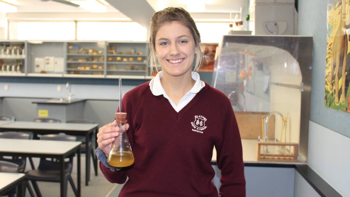 BRIGHT MIND: Tia Davis with a beaker containing a copper solution. 