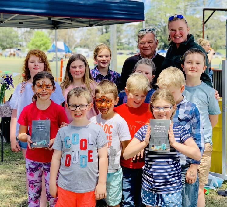 BIG GRINS: Author Russell Hodge with Neville Public School principal Tracy Blattman with students from the school at the Neville Show on Saturday. Photo: SUPPLIED. 