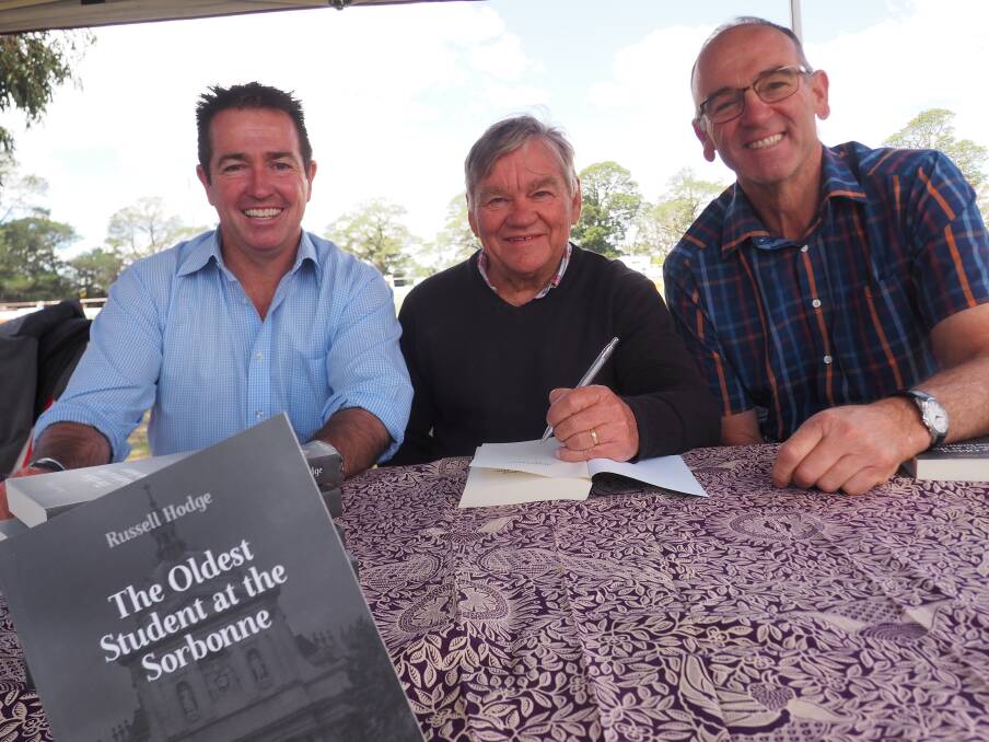 SIGNED COPY: Paul Toole, Russell Hodge and Scott Ferguson at the Neville Show on Saturday where Mr Hodge was launching his book and donating the proceeds to the school. Photo: SUPPLIED. 