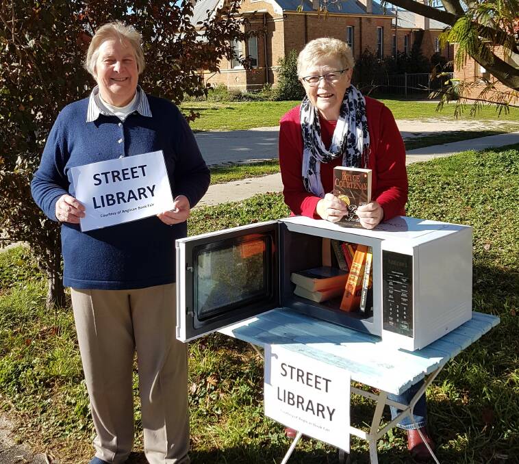 Elizabeth Russ and Janet Power readying the salvaged microwave oven for the Anglican Church Street Library.
