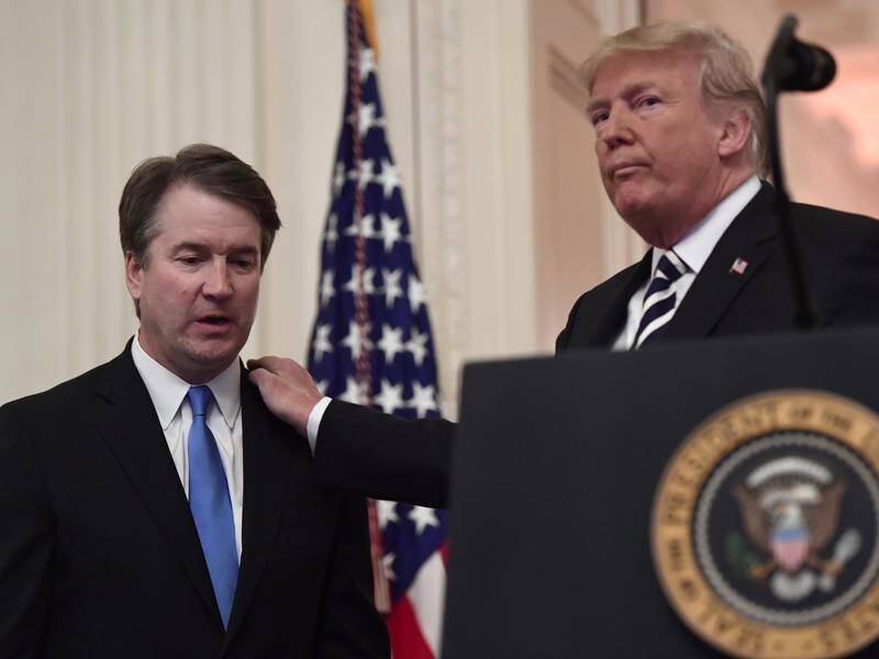 President Trump has defended Supreme Court Justice Brett Kavanaugh (L) over a new misconduct claim.