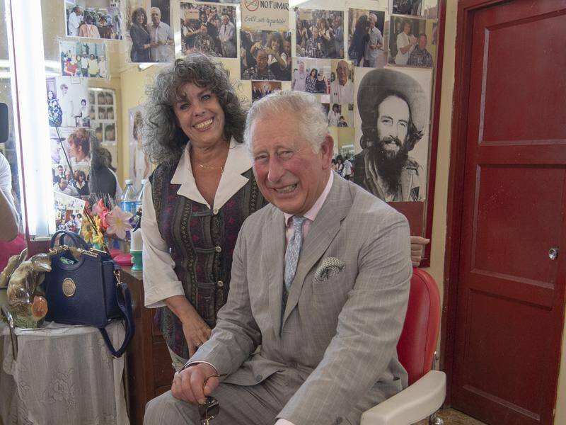 The Prince of Wales in a barber shop with owner Josephine Nandes during a tour of Old Havana, Cuba.
