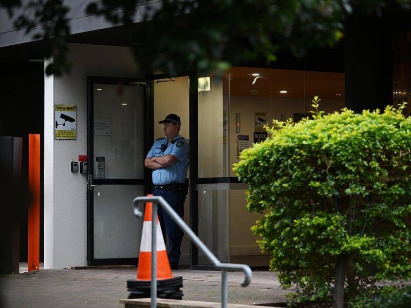 Police stand guard at a Sydney building where a three-year-old boy was found with stab wounds. (Dean Lewins/AAP PHOTOS)