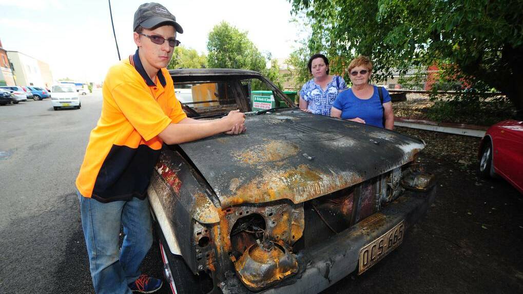 DUBBO: Julian Kilby with mother Marls Kilby and grandmother Mabel Kilby in front of the remains of his torched ute. Photo BELINDA SOOLE