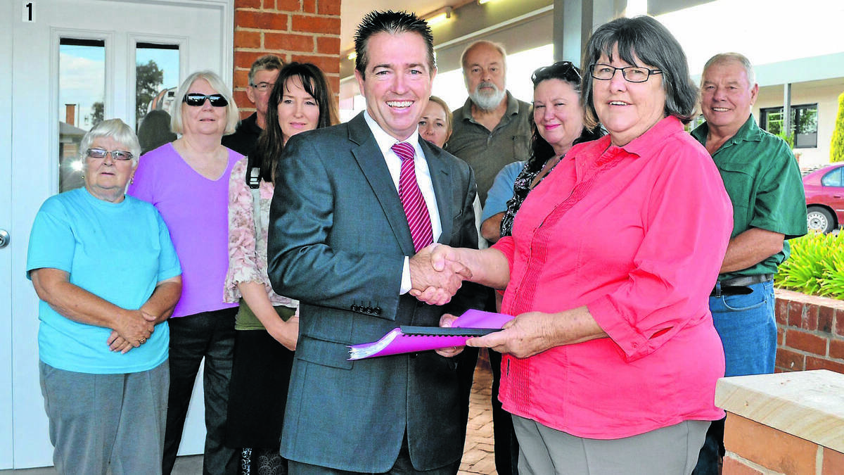 Member for Bathurst Paul Toole receives a petition from Newbridge Progress Association secretary Jan Dickie asking that the railway station be reopened. Photo: LOUISE EDDY	031815lepetin