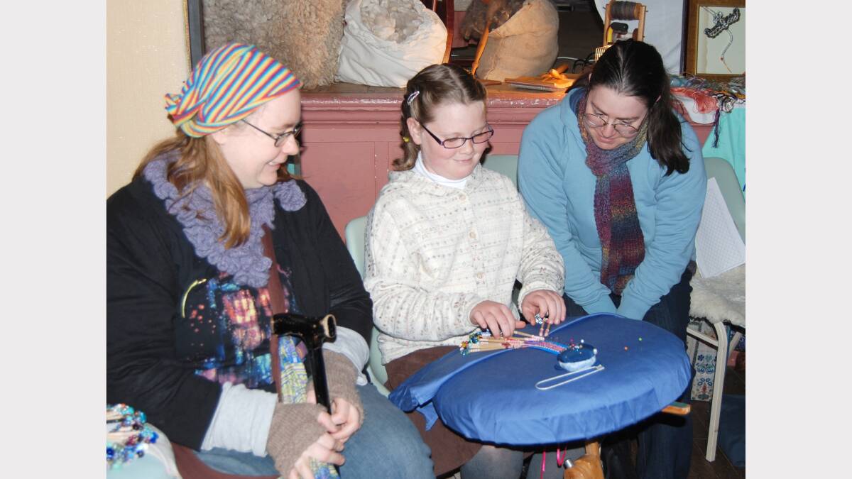 Youngest instructor. Anna Skinner (centre) demonstrates the art of Bobbin Lace making to Emma Pocock and Ruth Faraday in the School of Arts at Carcoar.  Photo: Wayne Cock.